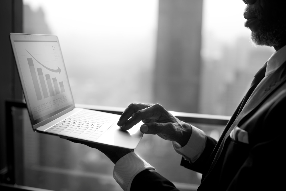 a laptop showing number decreasing. a man holding it with his left hand.